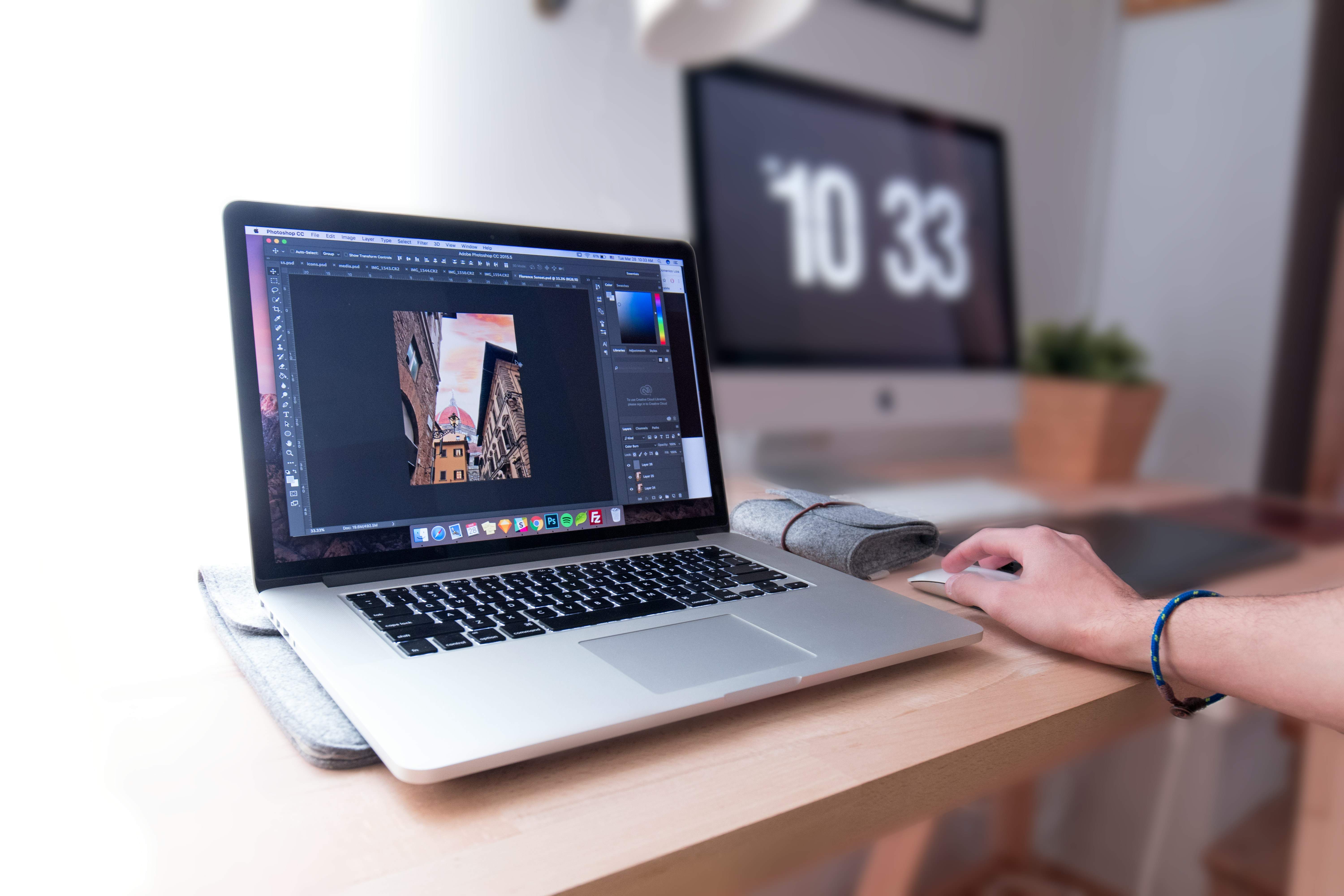 person-using-macbook-pro-on-brown-wooden-desk