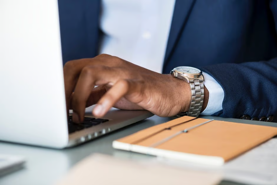 photo-of-person-wearing-gray-analog-watch-tapping-keyboard-of-laptop