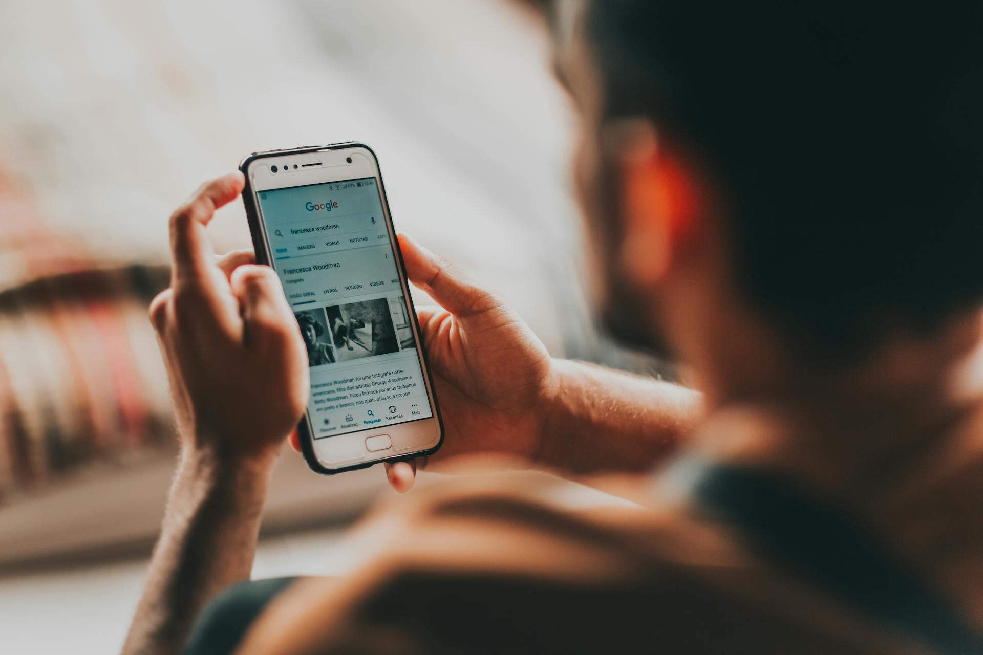 crop-man-surfing-internet-on-smartphone-at-home