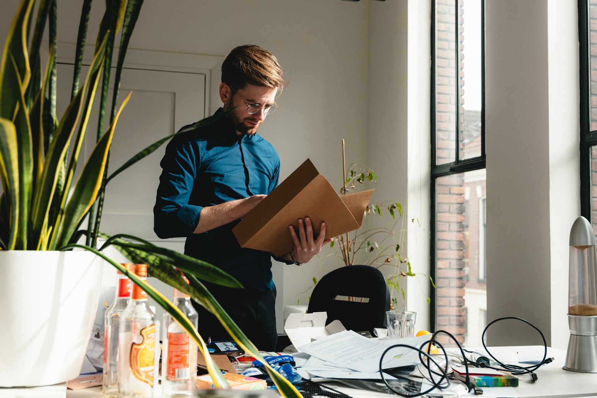 a-man-standing-in-an-office-holding-a-box