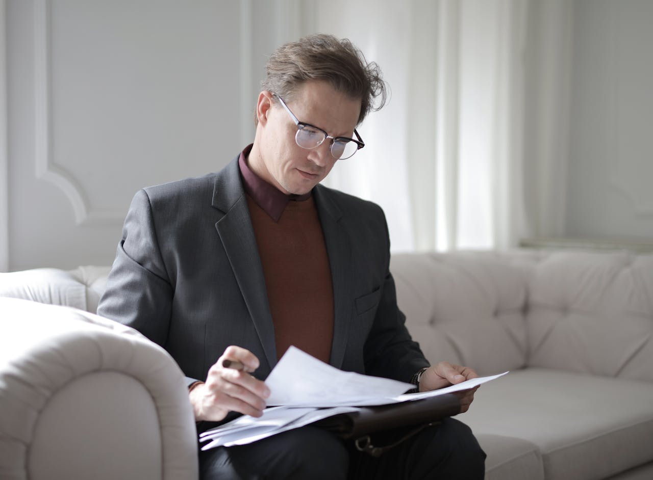 classy-executive-male-reading-papers-on-couch