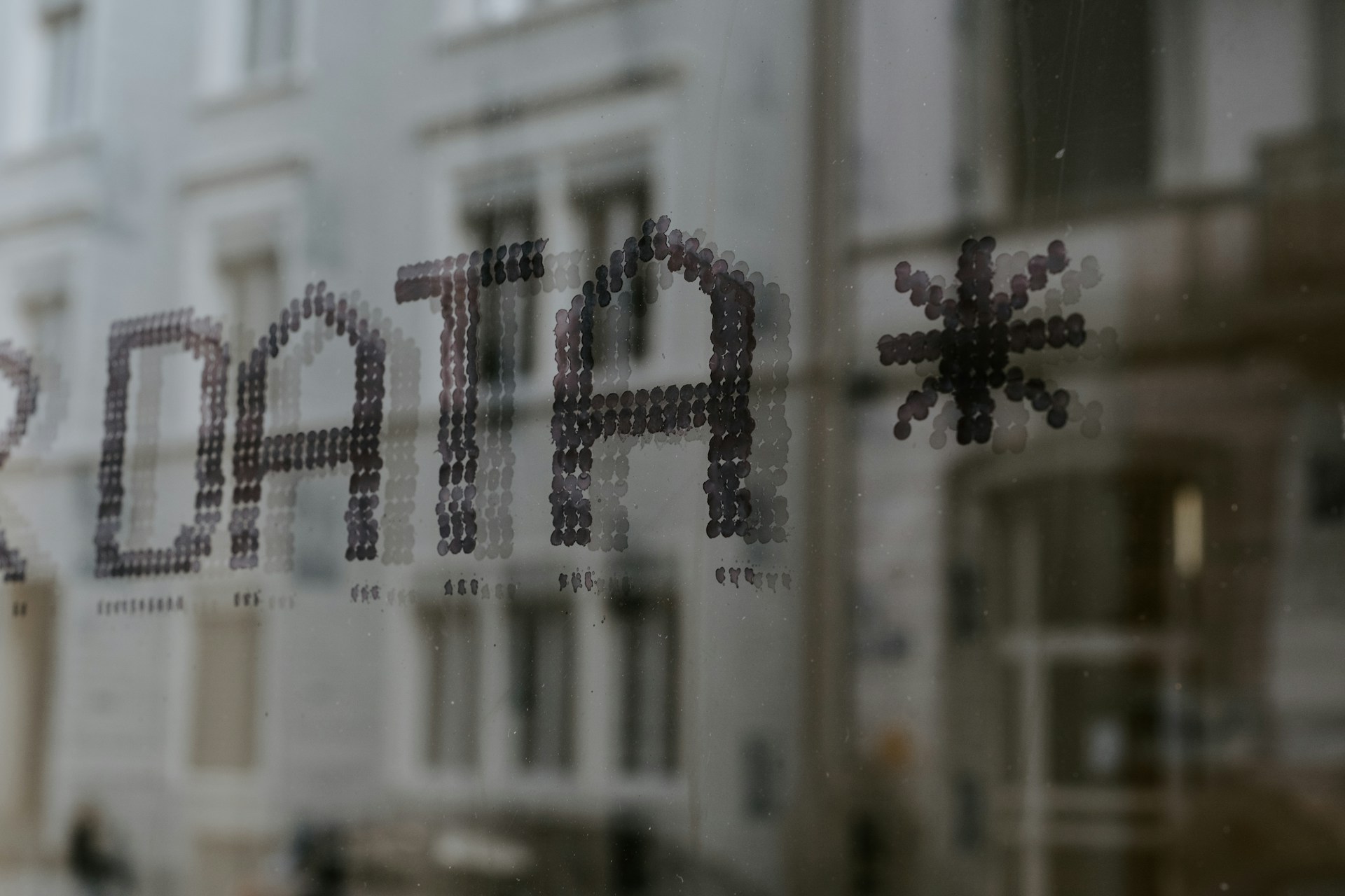 a-close-up-of-a-window-with-a-building-in-the-background