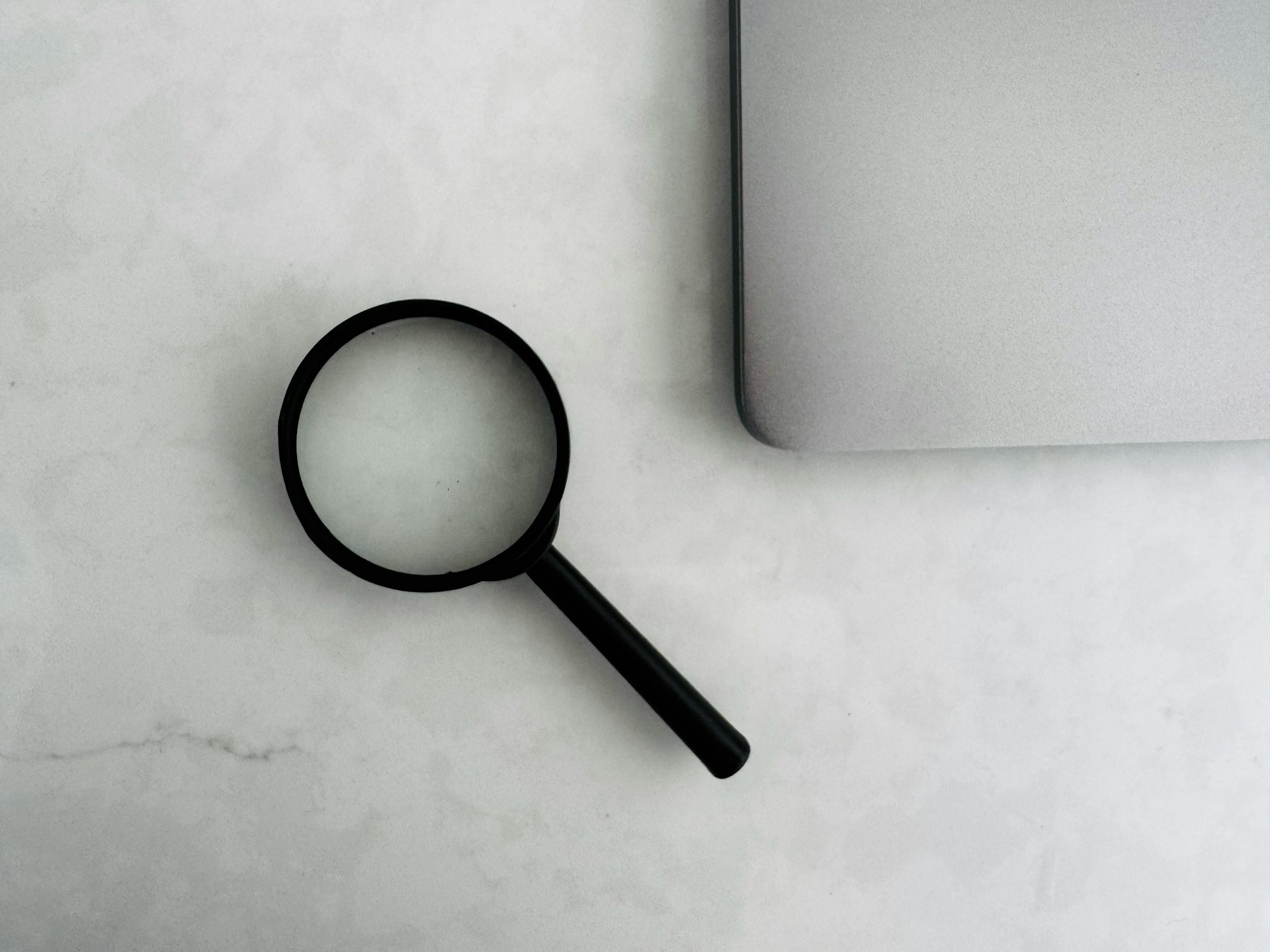 magnifying-glass-sits-near-a-laptop-on-a-table