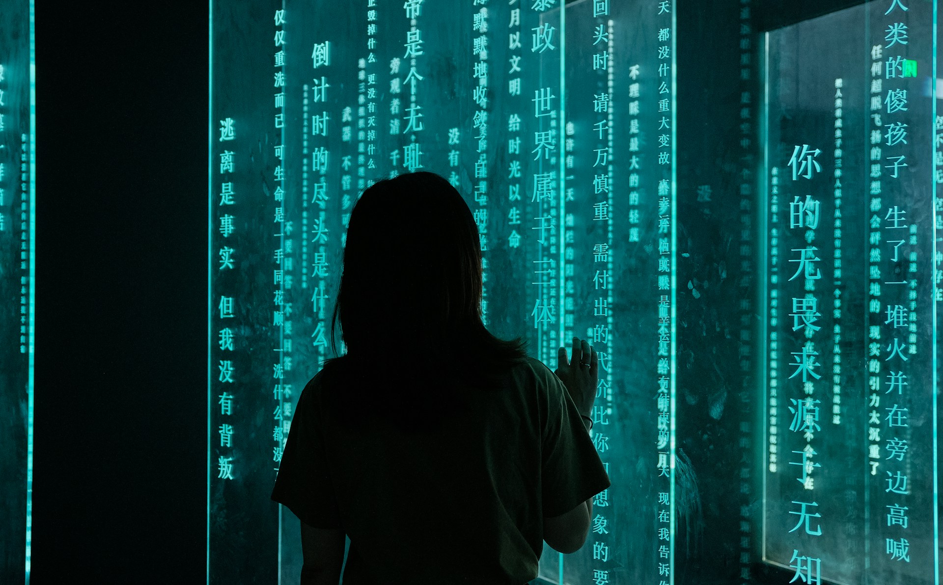 silhouette-of-woman-standing-in-front-of-blue-light